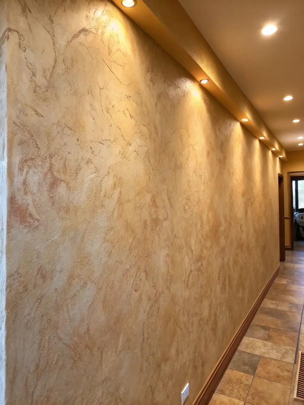 A close-up shot of a dark gray Venetian plaster wall finish with subtle gold veining, showcasing the texture and depth of the material.